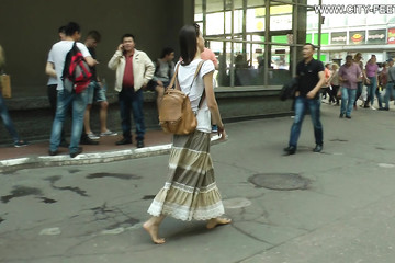 Девка ходит босиком по городу и показывает свои ножки
